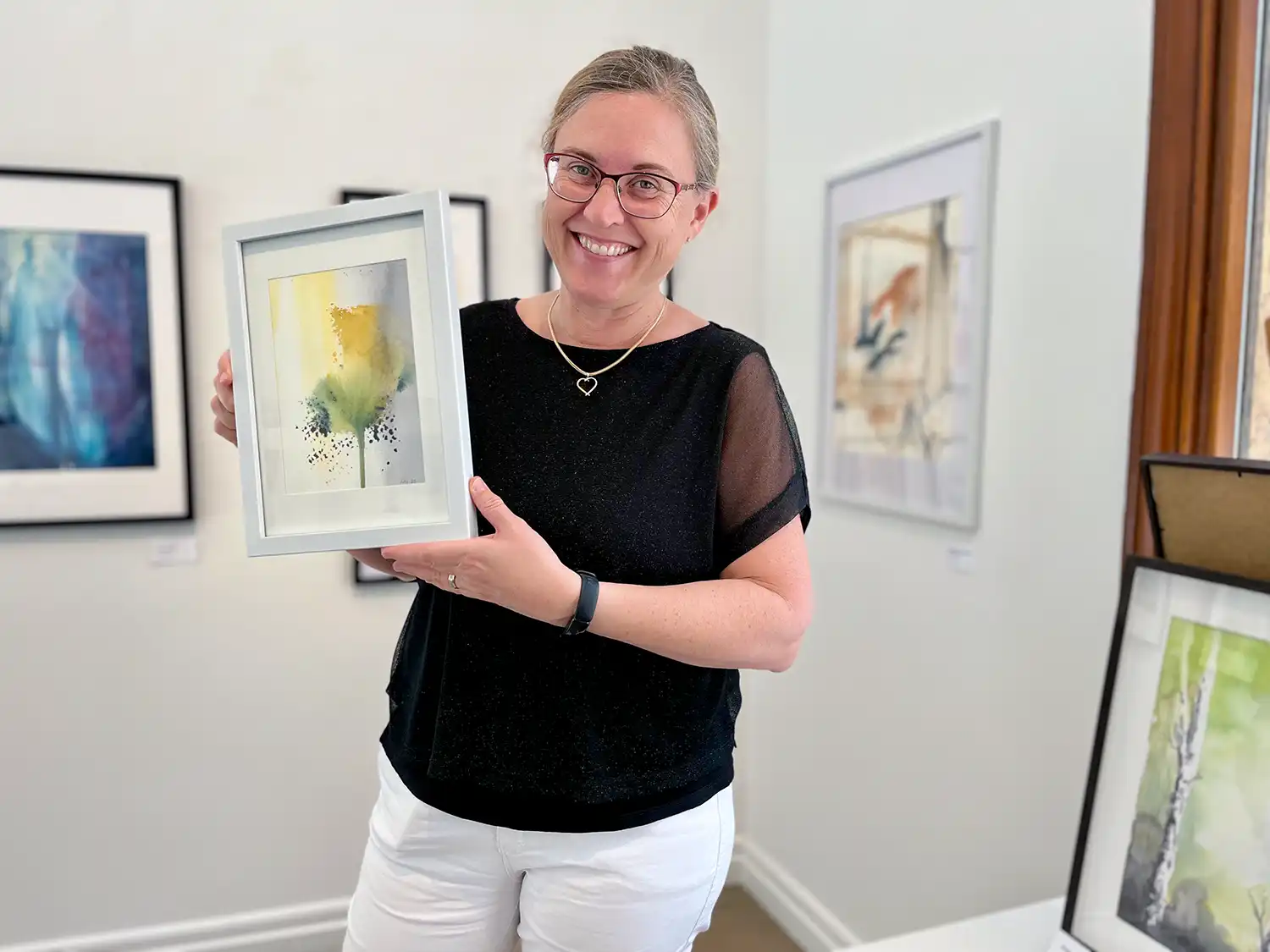 Helene Engström i ateljén i Norrköping. På fotot syns en suddig bild av Helene när hon med hjälp av en pendel formar ansiktet på lerfiguren. Fokuset i bilden ligger på lerfiguren hon arbetar med. Längst ner på skulpturens rygg står det Helene intryckt med hjälp av en stämpel.